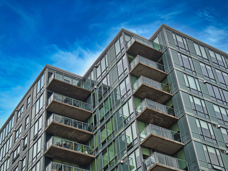 Condo building with balconies against a blue sky