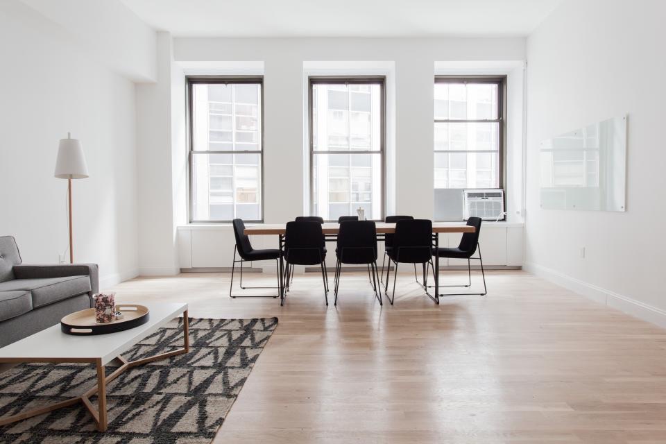 Dining area in a bright room with three windows