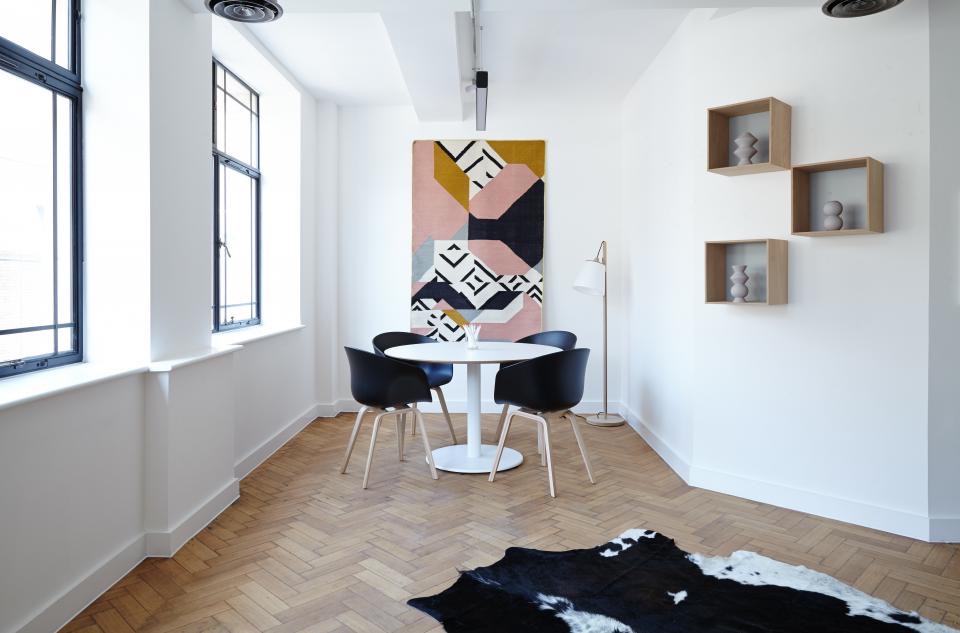 Round white table with black chairs by the window
