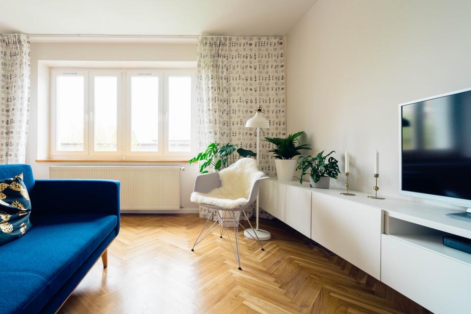 Sunlit living room with a blue sofa and herringbone floor