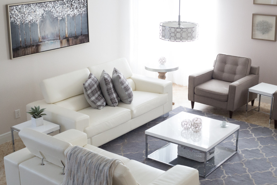 White living room with a leather sofa and grey rug